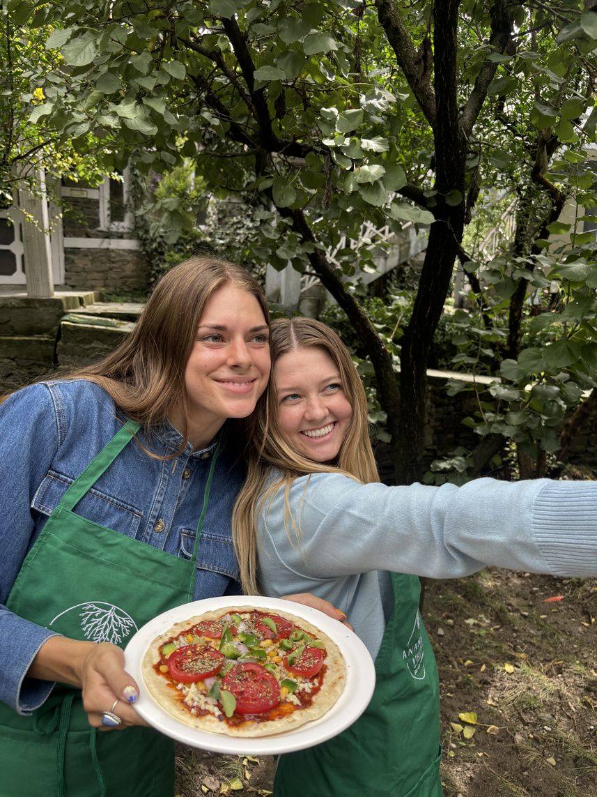 Smiling guests with a fresh pizza